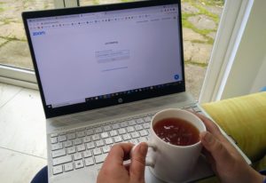 Computer with Zoom open and cup of coffee